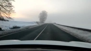 Güneşin doğuşunda sisli bir yolda kötü bir görüşle araba sürmek
