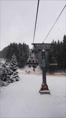 Bukovel, Ukrayna, 13 Ocak 2021: Kar yağarken teleferiğe binmek