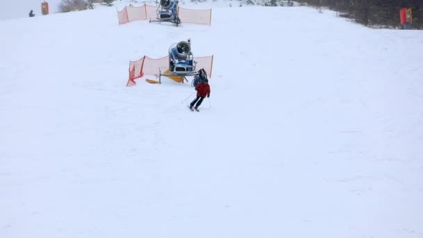 Mensen skiën en snowboarden stoeltjeslift op achtergrond — Stockvideo