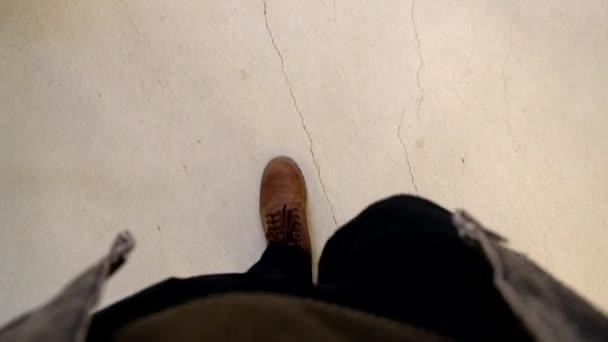 Pinta de ver piernas de los hombres en jeans negros y botas marrones — Vídeo de stock