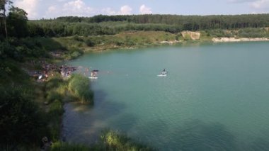 Yemek tahtalarında yüzen, güneşlenen insanların hava görüntüsü. yaz gölü aktiviteleri