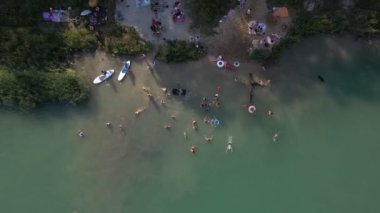 Yemek tahtalarında yüzen, güneşlenen insanların hava görüntüsü. yaz gölü aktiviteleri