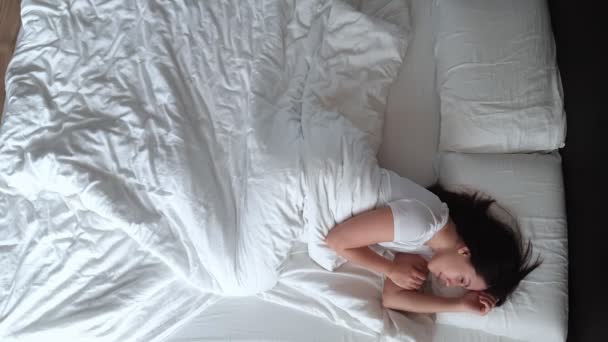 オーバーヘッドビュー女性がベッドで目を覚ます — ストック動画
