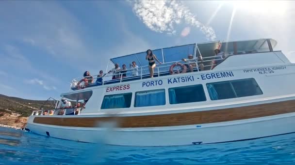 Lefkada, Řecko - 04. září 2021: žena skákající z lodi v čisté mořské vodě