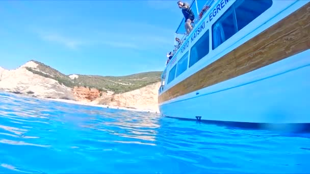 Lefkada, Řecko - 04. září 2021: muž skákající z lodi v čisté mořské vodě — Stock video