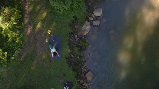 Femeia face yoga pe plaja râului munte — Videoclip de stoc