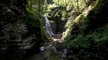 Manyava, Ukrayna - 31 Temmuz 2021: Kanyonla şelaleye yürüyen insanlar