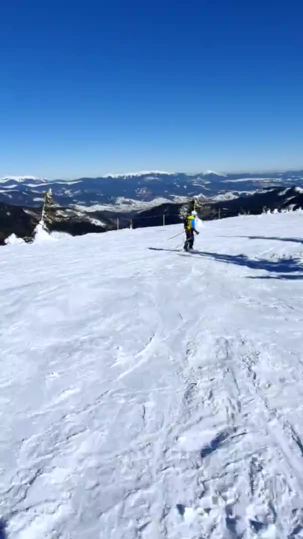 Esquiadora en la ladera de la montaña soleada — Vídeos de Stock