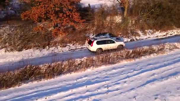 Vista aérea del coche todoterreno en la carretera de campo nevado — Vídeo de stock