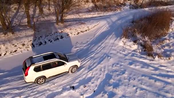 Luchtfoto van SUV auto verplaatsen door besneeuwd veld — Stockvideo