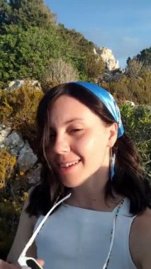 Kadın kamera önünde konuşuyor. Deniz tatili.