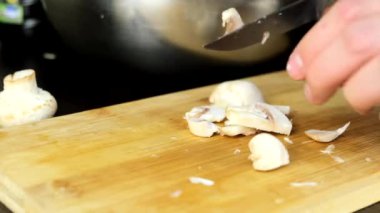 Mutfakta yemek pişirmek kesme tahtasında mantar doğramak