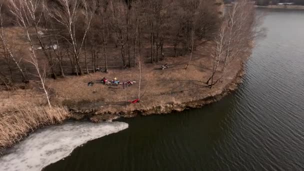 Overhead view of people resting at the beach of early spring lake — Stock Video