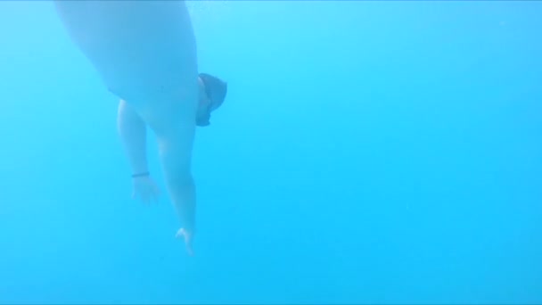 Человек плавает под водой в маске для акваланга и ластах — стоковое видео
