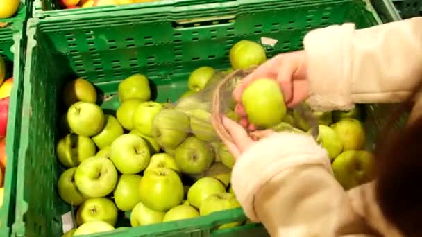 Kvinna i mask välja äpplen i mataffären — Stockvideo