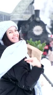 Çam ağacı buketi kadın ellerinde tren istasyonunda bekliyor.