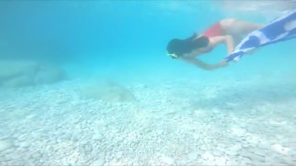 Женщина ныряет под воду с греческим флагом — стоковое видео