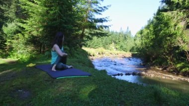 Kadın, Mountain River Plajı 'nda yoga yapıyor.