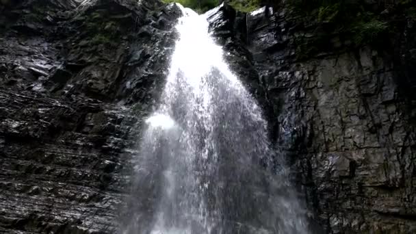 Симпатичная туристка, стоящая перед большим водопадом — стоковое видео