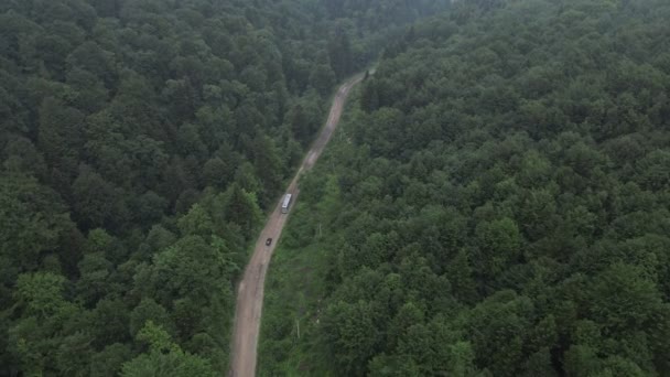 Autobús que conduce por carretera forestal en las montañas después de la tormenta — Vídeo de stock
