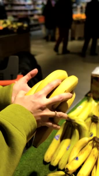 Frau entscheidet sich für Banane in Ladenhand — Stockvideo