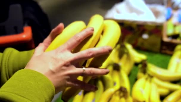 Frau entscheidet sich für Banane in Ladenhand — Stockvideo