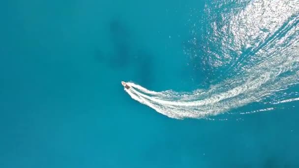 Vista aérea del barco en el agua azul del mar wakesurfing — Vídeo de stock