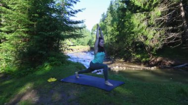 Kadın, Mountain River Plajı 'nda yoga yapıyor.