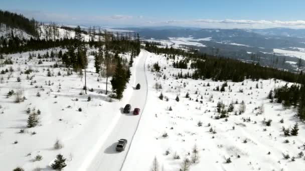 山の中の雪道を移動する車の空中風景 — ストック動画