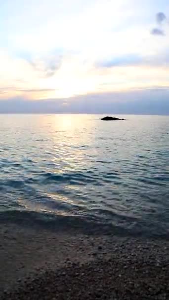 Auringonlasku meren rannalla jahti vene taustalla — kuvapankkivideo