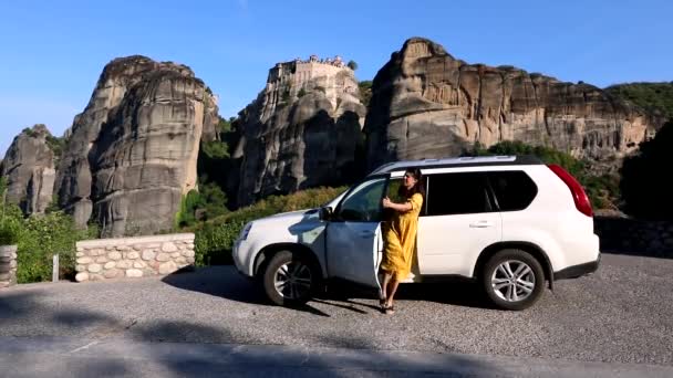 Kobieta wysiąść z samochodu, aby spojrzeć na szablon na klifie — Wideo stockowe