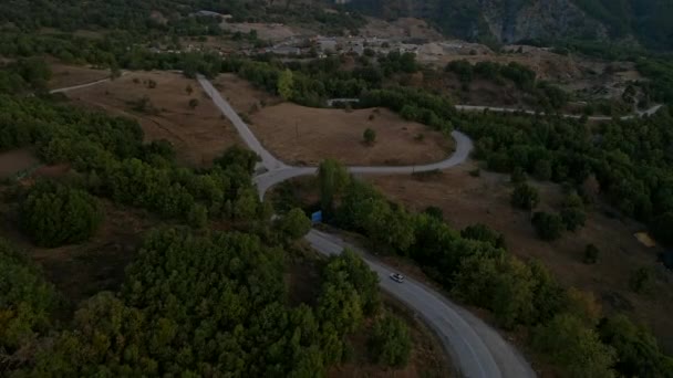 Вид с воздуха на внедорожник, движущийся по греческой горной дороге — стоковое видео