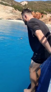 Adam tekneden denize atlıyor.