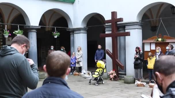Lviv, Oekraïne - 2 mei 2021: Paasvakantie mensen in de buurt van kerk met manden — Stockvideo