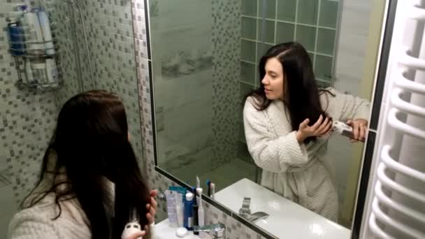 Happy woman dry hair in front of mirror in bathroom singing — Vídeos de Stock