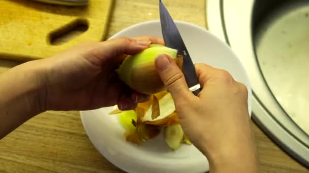 Woman clean up onion on the kitchen — Videoclip de stoc