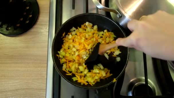 在家里做饭家庭厨房油炸胡萝卜和锅里的洋葱 — 图库视频影像