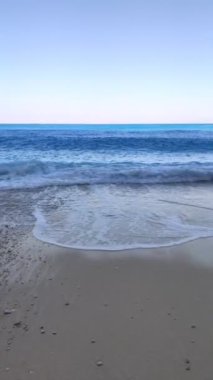 Dalgalı mavi deniz kumlu sahil