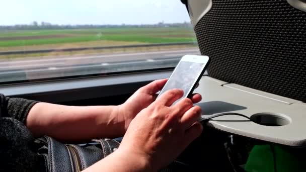 Vrouw surfen internet aan de telefoon tijdens het reizen met de bus — Stockvideo
