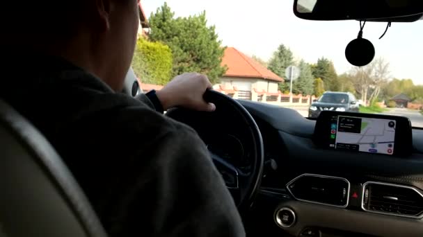 Man driving car by city view from rear seats — стоковое видео