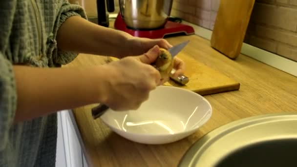 Woman clean up onion on the kitchen — Wideo stockowe
