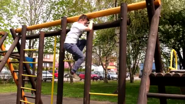 Маленький хлопчик сходження на дитячий майданчик на відкритому повітрі — стокове відео