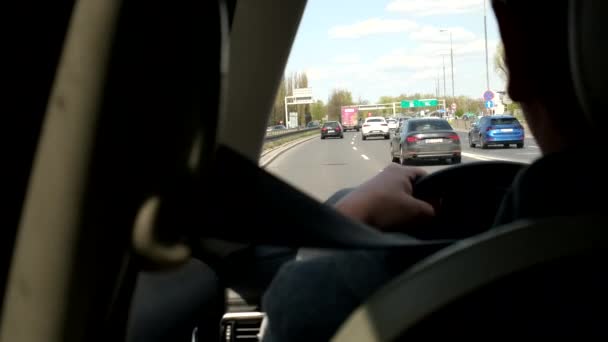 Mężczyzna jazdy samochód przez miasto widok z tyłu siedzenia — Wideo stockowe