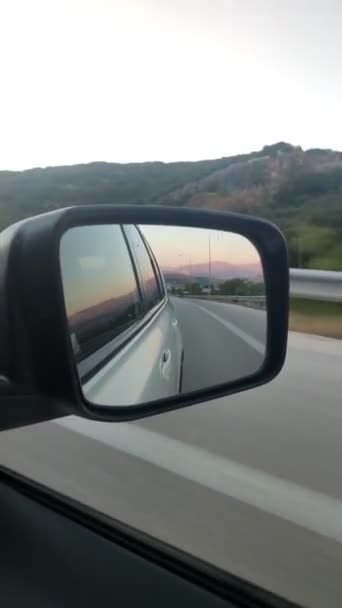 Puesta de sol en las montañas reflejo en espejo retrovisor — Vídeos de Stock