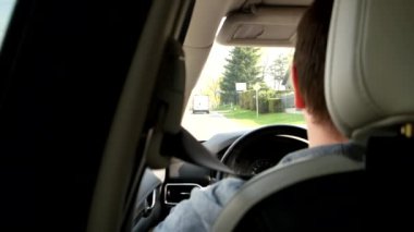 man driving car by city view from rear seats
