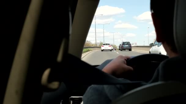 Mężczyzna jazdy samochód przez miasto widok z tyłu siedzenia — Wideo stockowe