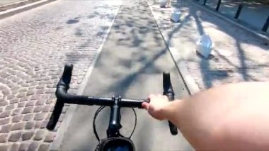 person view driving bicycle by city street