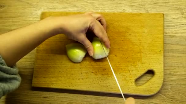 Подрібнення цибулі на різаній дошці — стокове відео