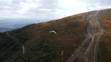 following after paraglider flying above ukrainian carpathian mountains