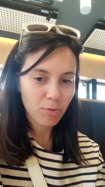 レストランで食事をしながらカメラで話す若い大人の女性 — ストック動画